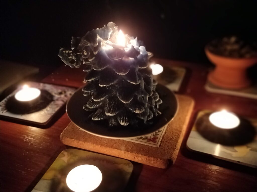 Winter Solstice Ritual featuring a candle shaped like a pine cone