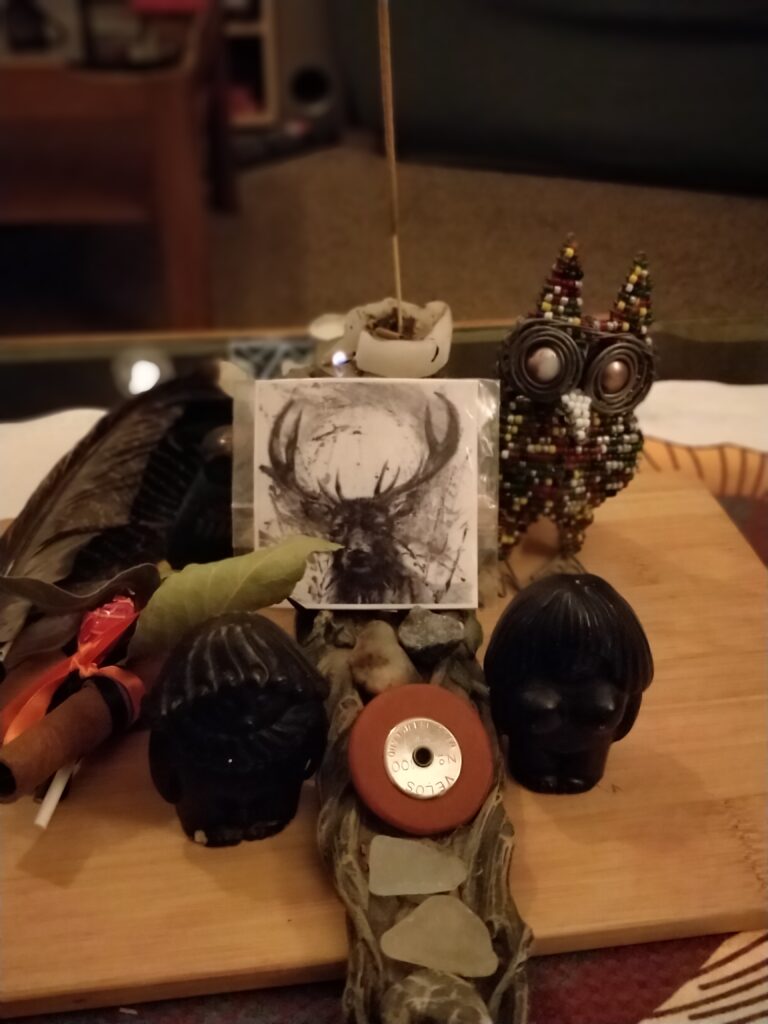 An altar, featuring a picture of a stag, an owl and balance between feminine and masculine